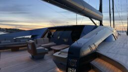 Sarissa Sailing Yacht Royal Huisman. Luxury yacht deck at sunset with seating area.