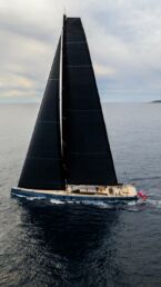 Sailboat Sarissa on open sea under cloudy sky.