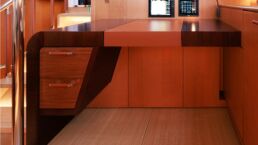 Modern yacht interior with wooden desk and storage. YYachts Y9 Sailing Yacht