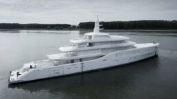 Amels 80 Motor Yacht. Large white yacht on a calm river.