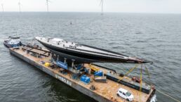 Hanuman Yacht Refit. Large J-Class yacht transported on platform in wind turbine sea