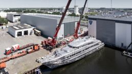 Yacht construction at an industrial shipyard with cranes