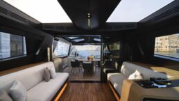 WallyWhy100 Motor Yacht. Luxury yacht interior with city view and sofas.