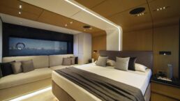 WallyWhy100 Motor Yacht. Luxury modern bedroom with ocean view and seating area.