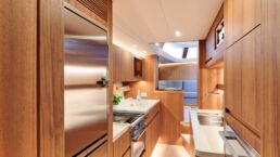 Contest 63CS Sailing Yacht Interior. Modern wood-paneled kitchen in a yacht