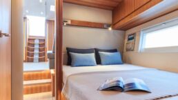 Contest 63CS Sailing Yacht Interior. Modern yacht cabin with double bed and pillows.