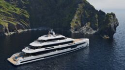 Setteesettanta Heesen Yachts. Luxury yacht sailing near rocky coastline