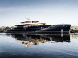 Luxury yacht ONE by Feadship docked in serene waters, sunny day.