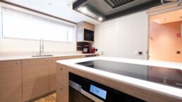 SAN Yacht Interior. Modern kitchen with light wood cabinets and appliances